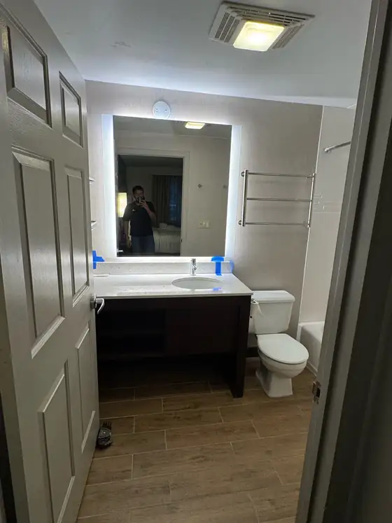 Finished bathroom with a dark vanity, framed mirror and new flooring