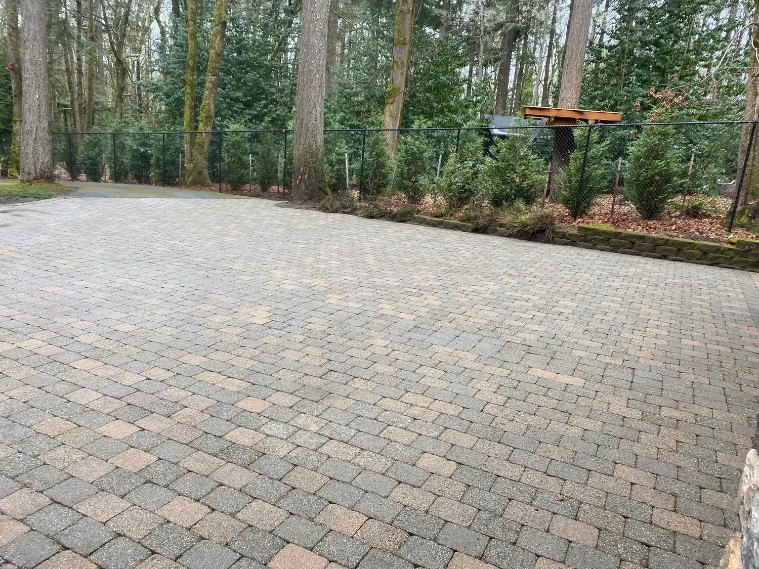 The same paver driveway after pressure washing, clean and evenly coloured