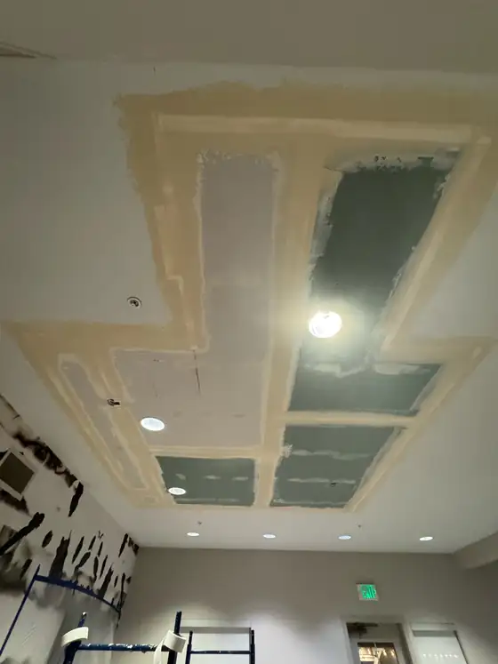 Joint compound going on across the new ceiling