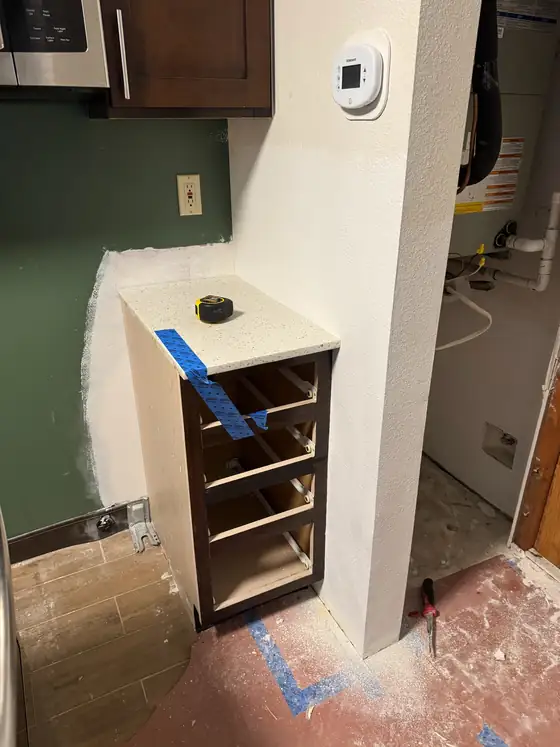 The custom cabinet carcass built into the gap beside the range