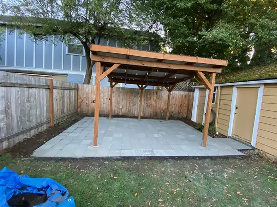 Finished cedar patio cover over a new paver patio in a fenced back garden
