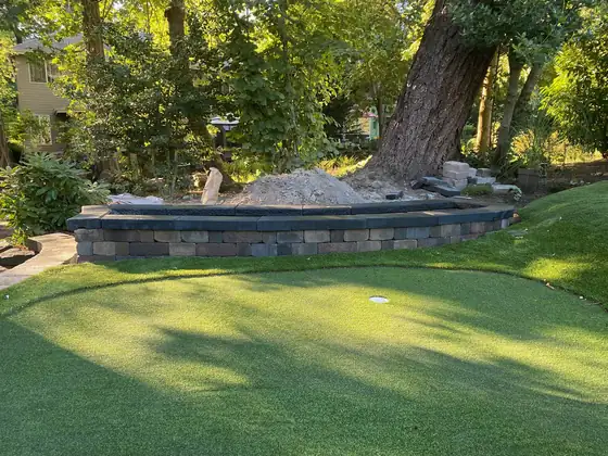 Completed retaining wall curving around under mature trees