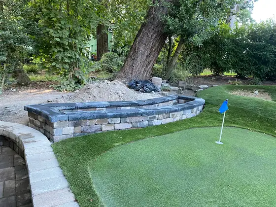 Capped block wall forming a planter and seat along the lawn edge
