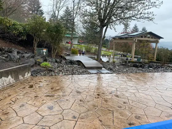 Stamped concrete patio sweeping past the finished pond