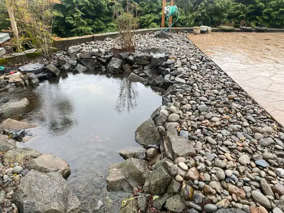 The filled pond edged with river rock
