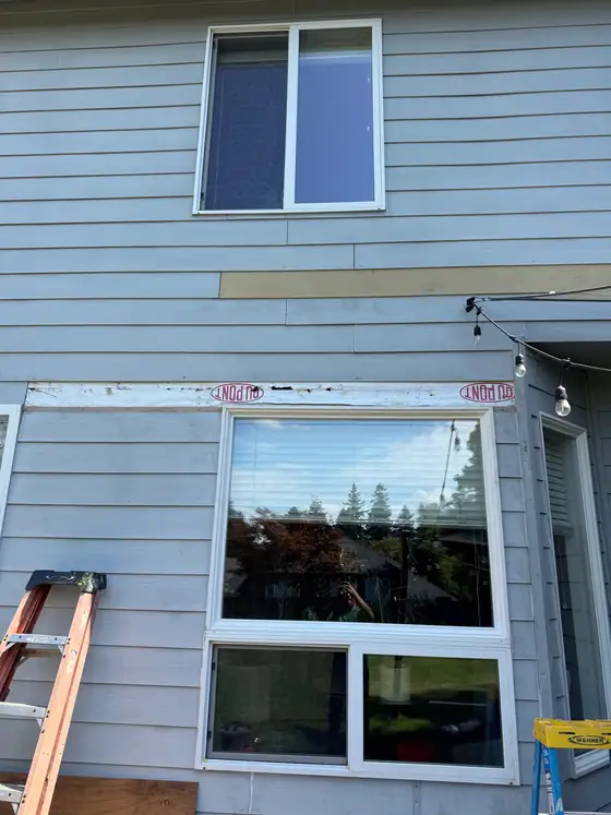 Siding and window trim being replaced on the upper storey