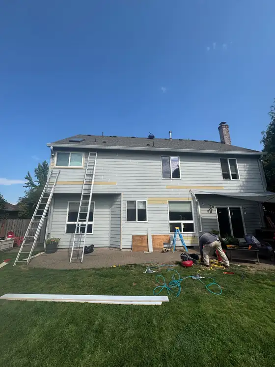 Ladders set against the house during the siding replacement
